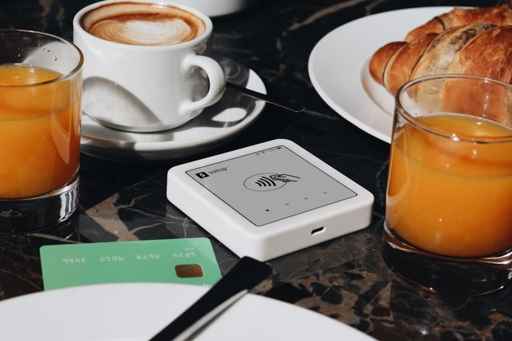 A SumUp card reader is placed on a table, ready to accept contactless payments. The setup is ideal for small businesses and cafés, offering a sleek and efficient way for entrepreneurs to accept payments.