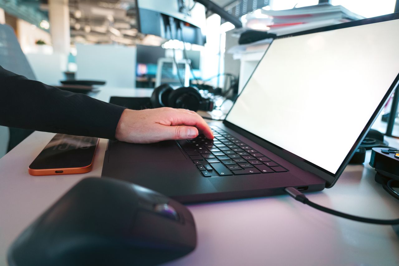 Mastering the First Impression: Your intriguing post title goes here Hand typing on a laptop keyboard in a sleek office environment, showcasing modern technology.